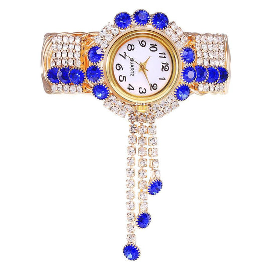 Gold-tone rhinestone bracelet watch with blue stones and clear crystals; round quartz dial