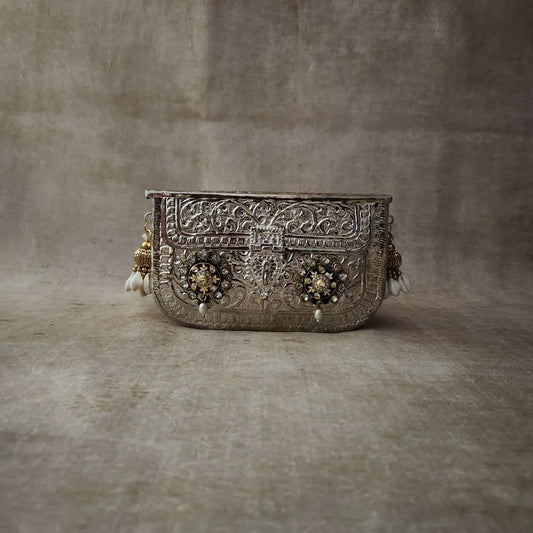 Embellished silver clutch with pearl tassel trim and ornate front panel