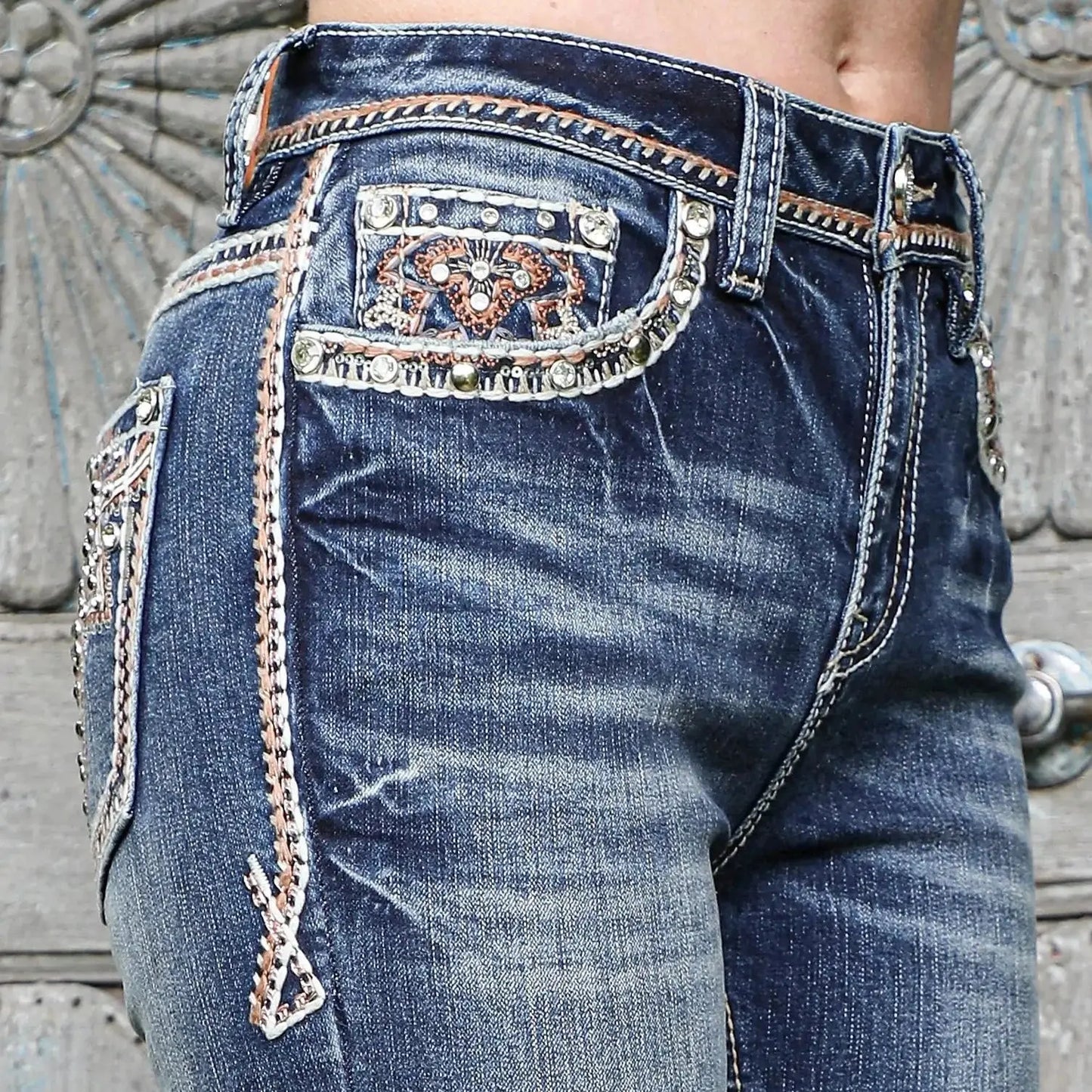 Jeans back-pocket detail, blue denim with ornate embroidery and decorative stitched panels