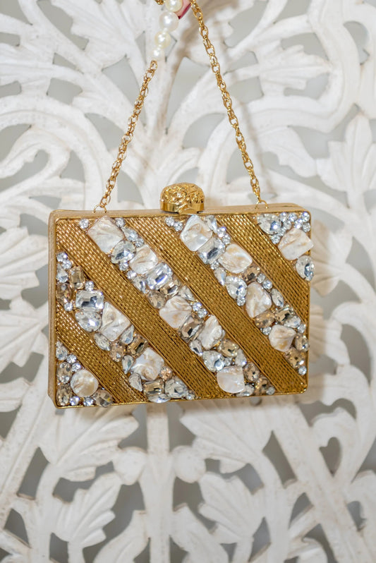 Gold jeweled clutch bag with diagonal rhinestone stripes and top clasp.