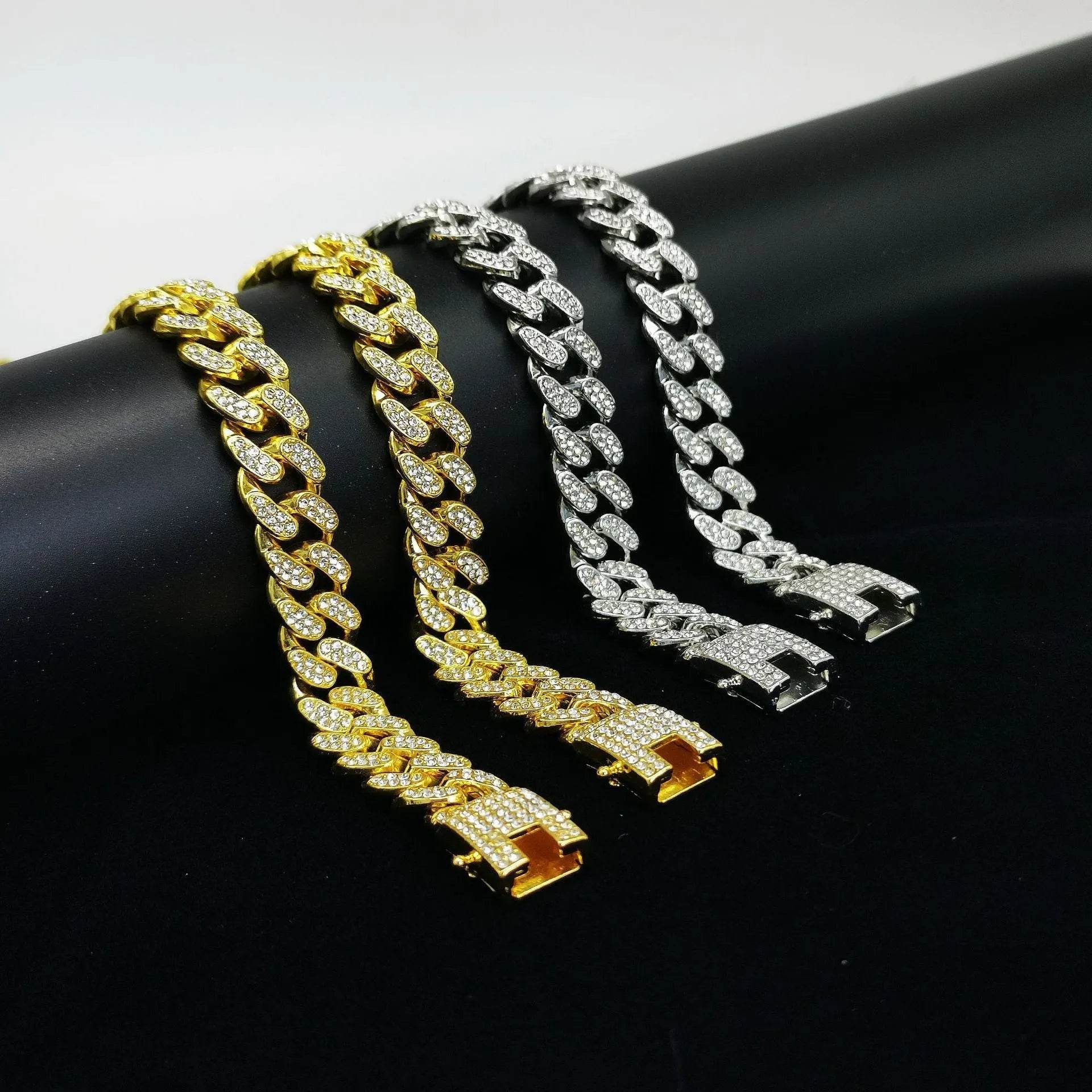 Gold and silver diamond Cuban link bracelets on a dark display surface.