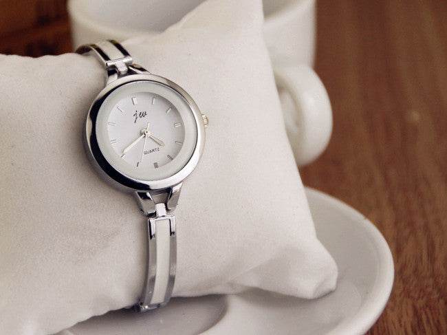 Silver watch bracelet close-up with round white dial and metal link strap