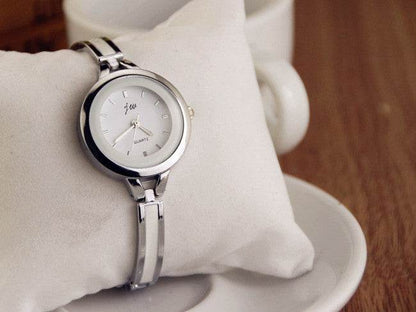 Silver watch bracelet close-up with round white dial and metal link strap