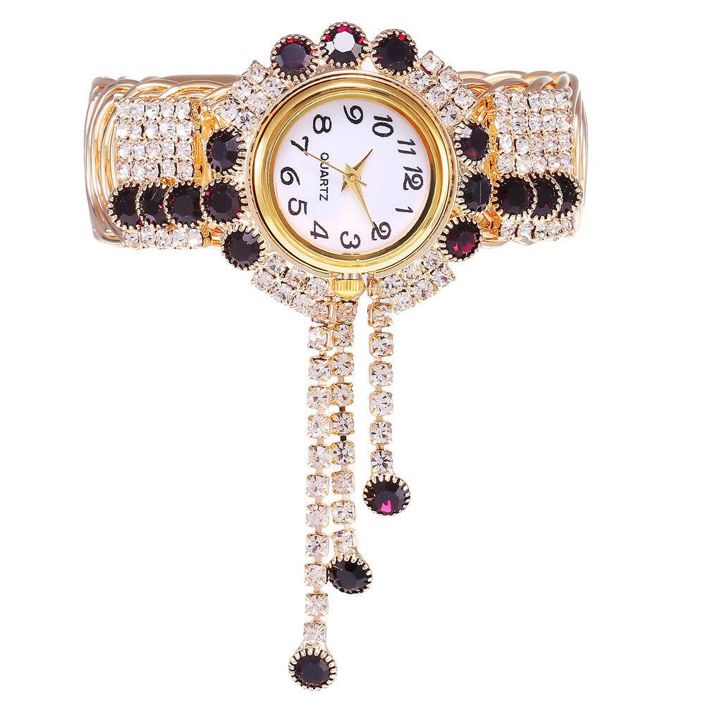 Gold-tone rhinestone bracelet watch with purple, black, and clear stone bezel and dial