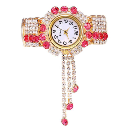 Gold-tone rhinestone bracelet watch with pink stones and clear crystals; round quartz face