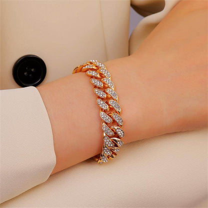Gold cuban chain bracelet with oval diamond-look stones, hinged clasp