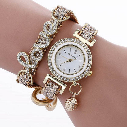 Rhinestone bracelet watch with round white dial, gold-tone bezel, and clear crystal accents