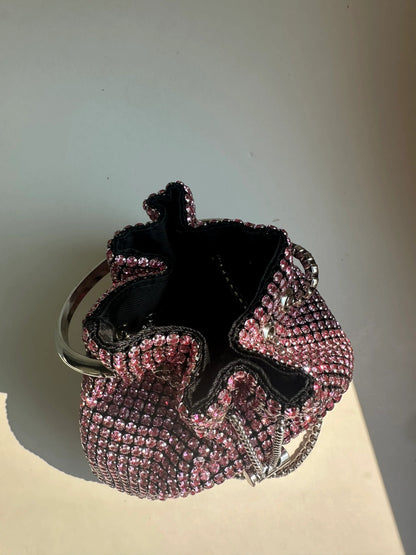 Pink rhinestone bucket bag open to show black fabric lining