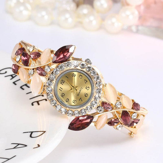 Gold-tone ladies bracelet watch with purple marquise stones and crystal bezel round dial