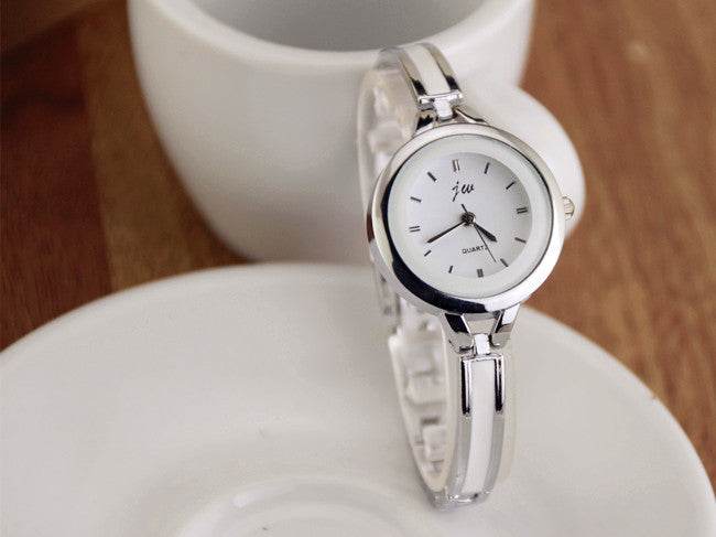 Silver watch bracelet with round white dial, minimal hour markers, and metal link strap