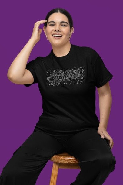 Person wearing a black t-shirt with 'America' printed on it against a purple background