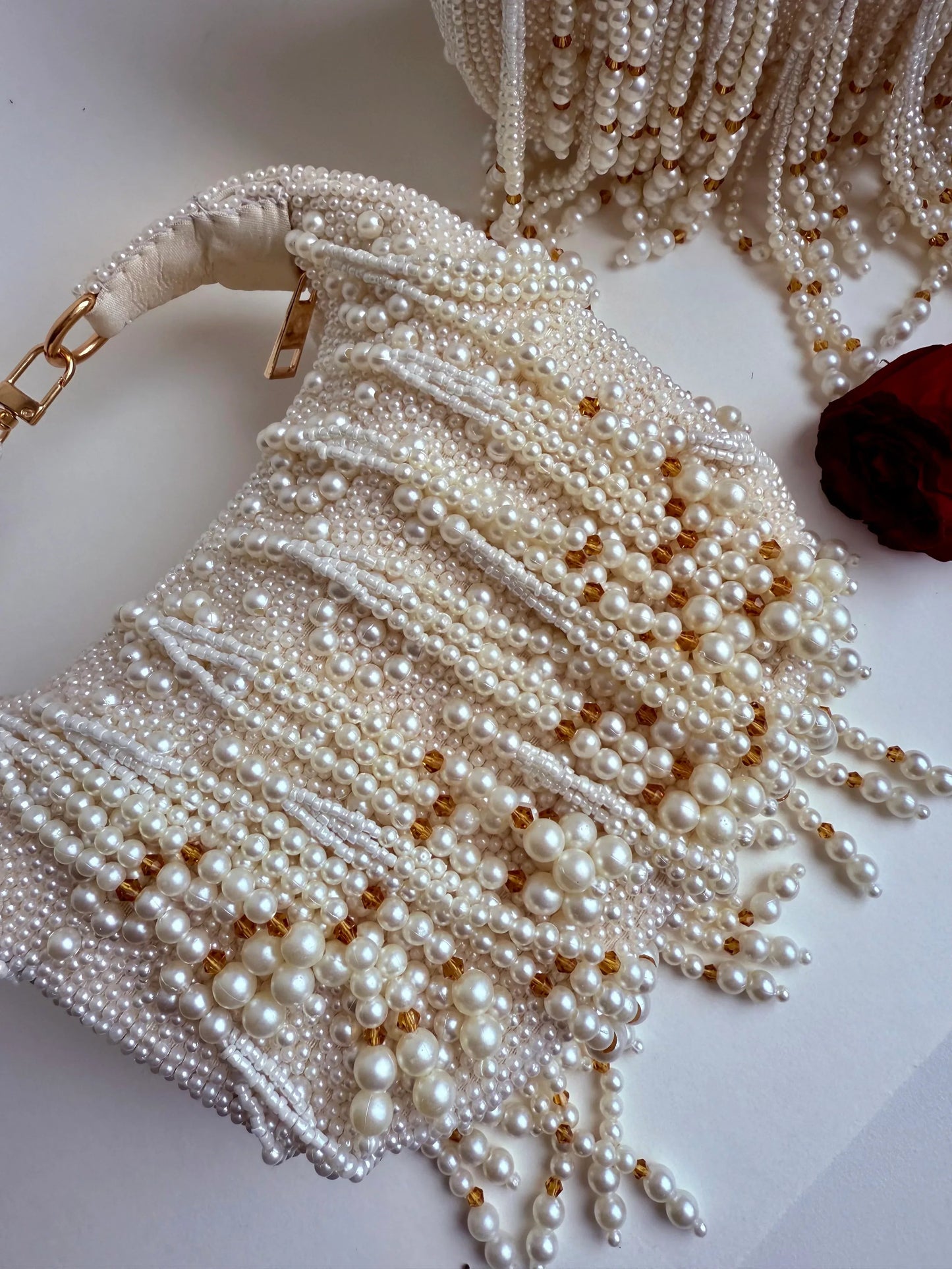 White pearl beaded clutch bag with tassel fringe and gold-tone accents