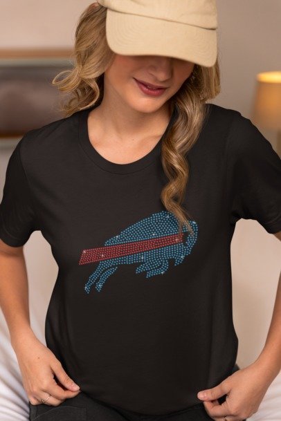 Woman wearing a black t-shirt with a blue and red graphic design, possibly a sports team logo.