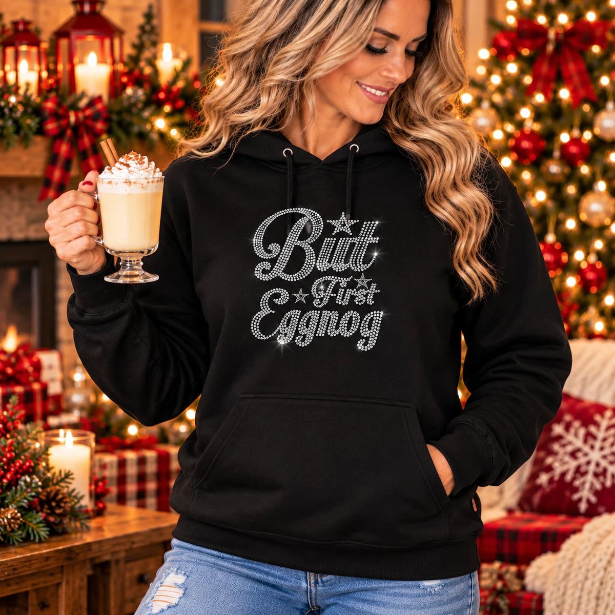 Black hoodie with silver rhinestone “But First Eggnog” lettering and front pocket