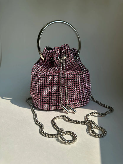Pink rhinestone bucket bag with chain strap, drawstring closure, and top handle