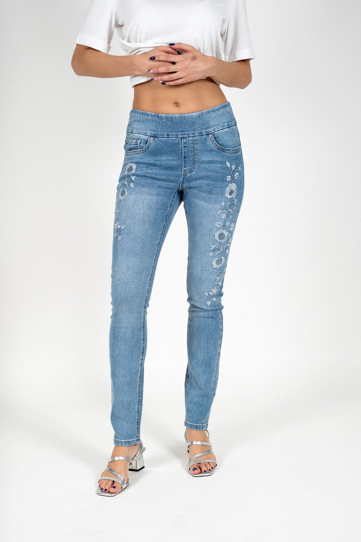 Light blue denim skinny jeans with floral rhinestone embroidery on leg