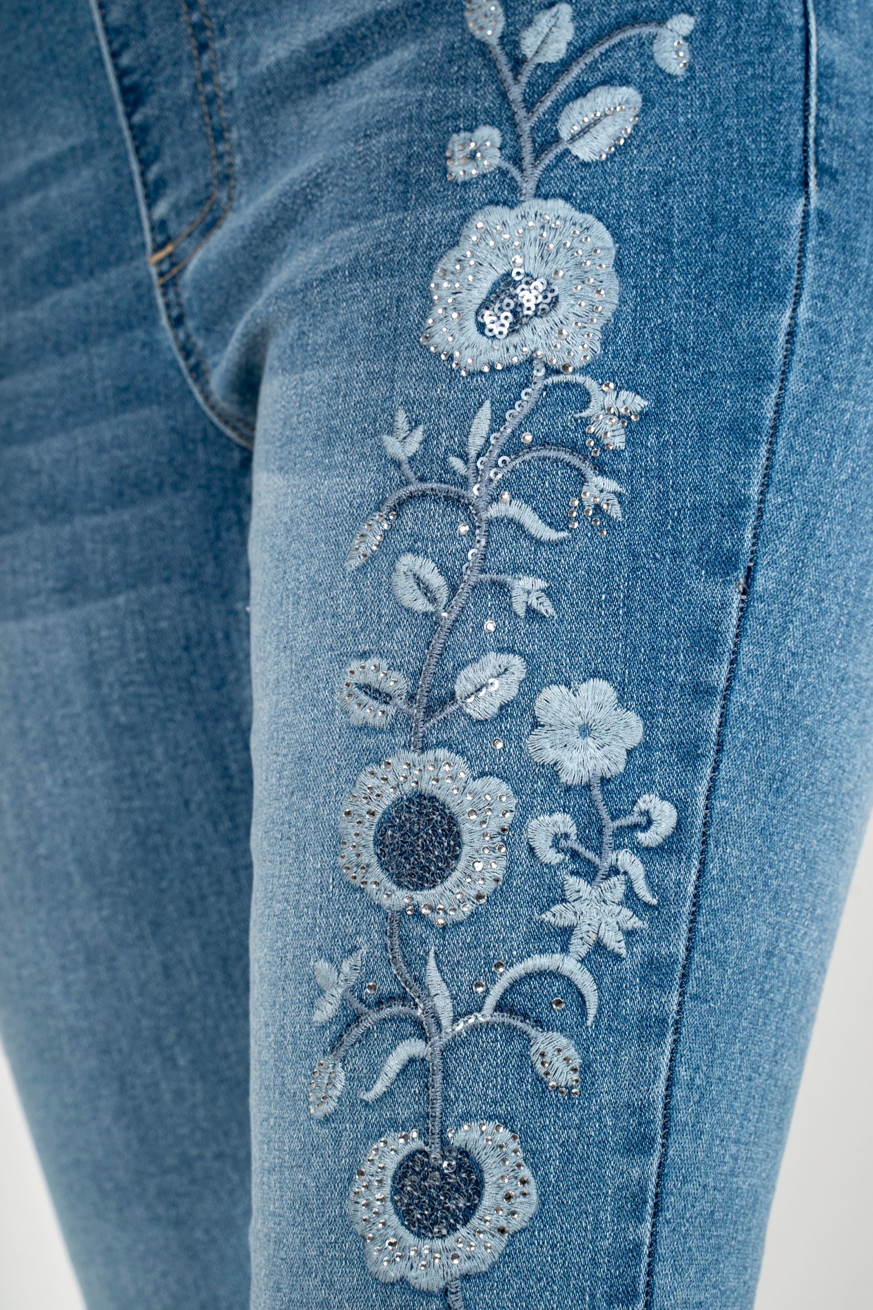 Light blue denim close-up with rhinestone floral pattern applique