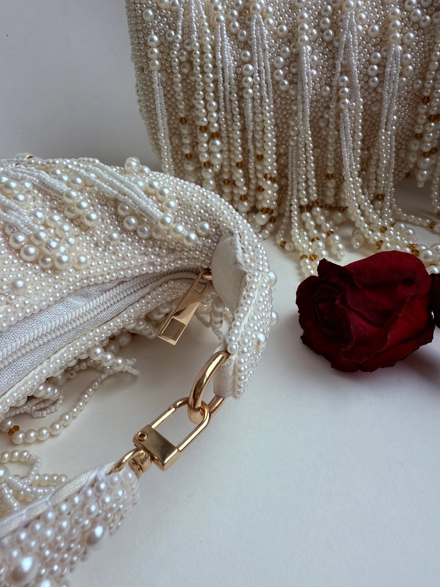 White pearl fringe clutch bag with gold-tone chain strap and clasp