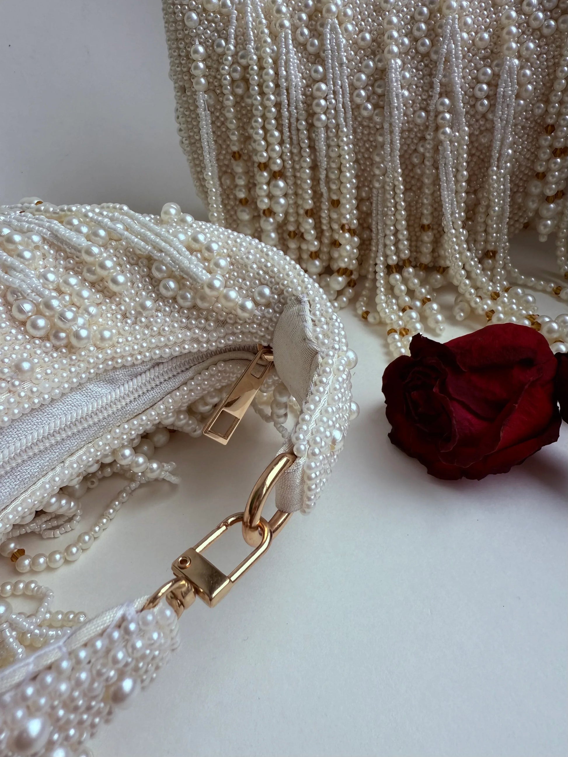 White pearl fringe clutch bag with gold-tone chain strap and clasp