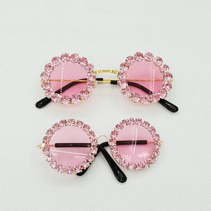 Pink rhinestone pet sunglasses with oval tinted lenses and black side arms