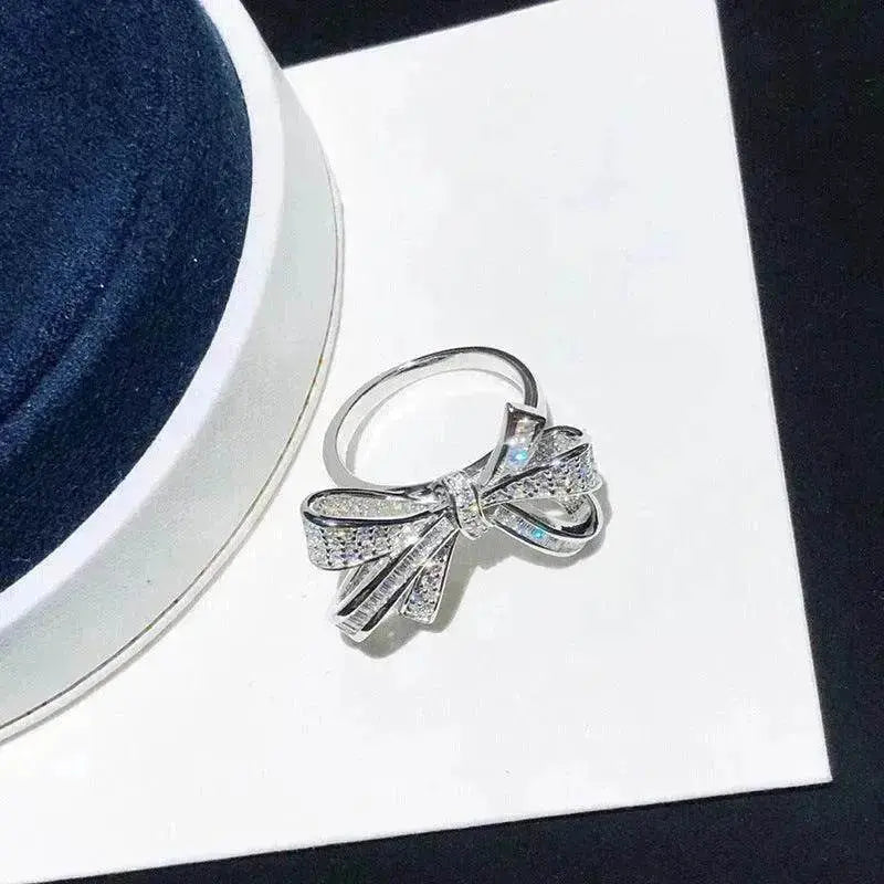 Silver-tone diamond bow ring on jewelry card, ribbon bow with prong-set stones