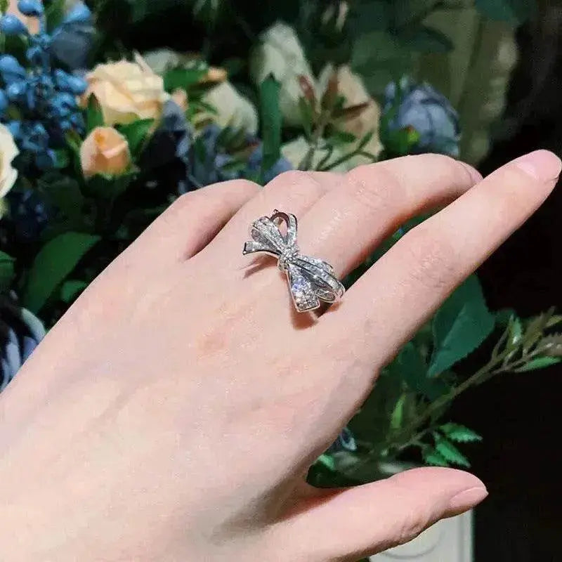 Silver-tone diamond bow ring on hand, sparkling ribbon bow with stone detailing