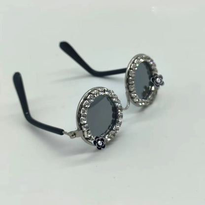 Rhinestone pet sunglasses with oval black lenses, curled arms, and flower charms