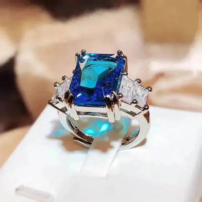 Blue square-cut crystal ring with silver band and rhinestone side stones