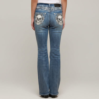 Blue jeans with skull designs on pockets against a plain background