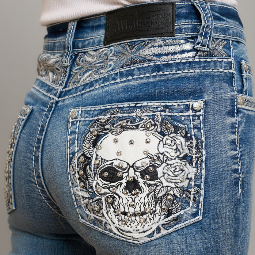Close-up of blue jeans with a decorative skull and rose design on the pocket.