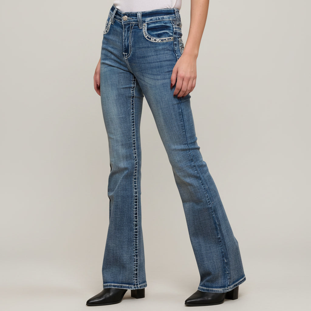 Blue flared jeans worn by a person on a plain background