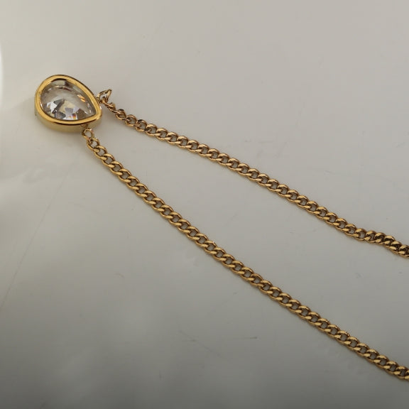 Gold-tone link chain necklace with teardrop crystal pendant and clasp end.