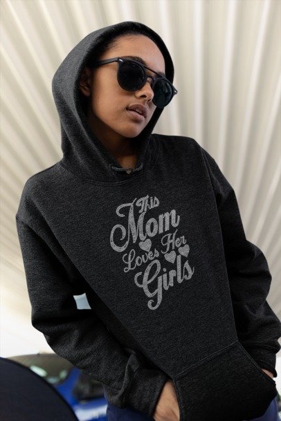 Dark hooded sweatshirt with rhinestone-style "This Mom Loves Her Girls" front