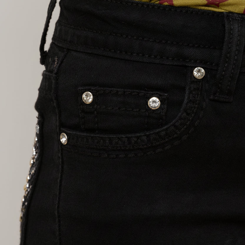 Black jeans close-up: front button fly and silver rhinestone pocket studs