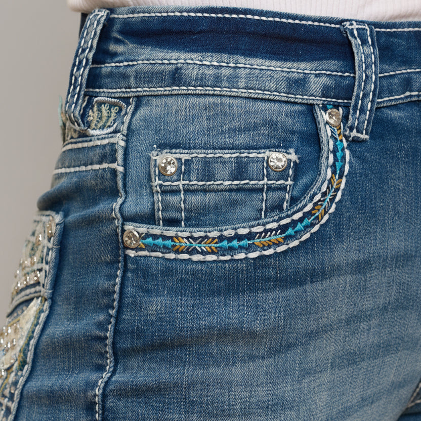 Blue denim jeans close-up of back pocket with rhinestone and thread embroidery
