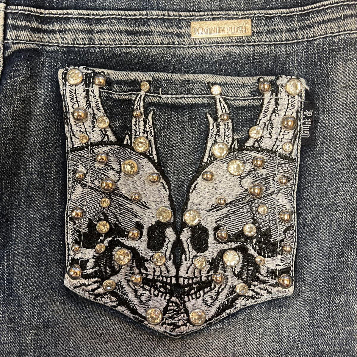 Rhinestone skull wing patch on front denim shorts pocket with metal studs
