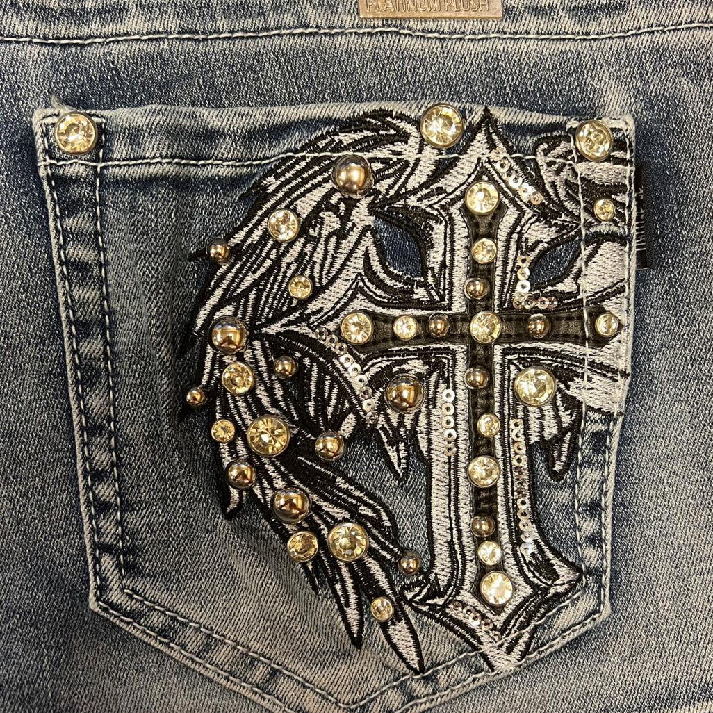 Blue denim shorts close-up of rhinestone angel wing cross pocket applique