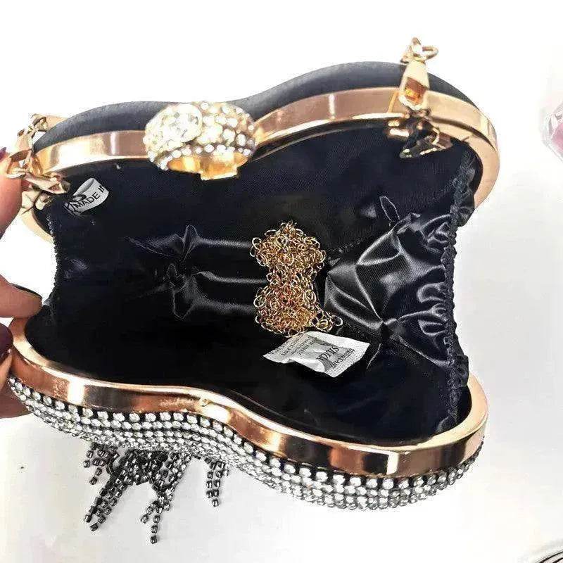 Black heart-shaped satin handbag open view with chain trim and rhinestone clasp