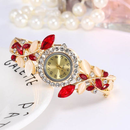 Gold-tone ladies bracelet watch with red stones and crystal bezel round dial